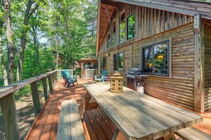 A wooden deck with outdoor seating and a barbecue area.