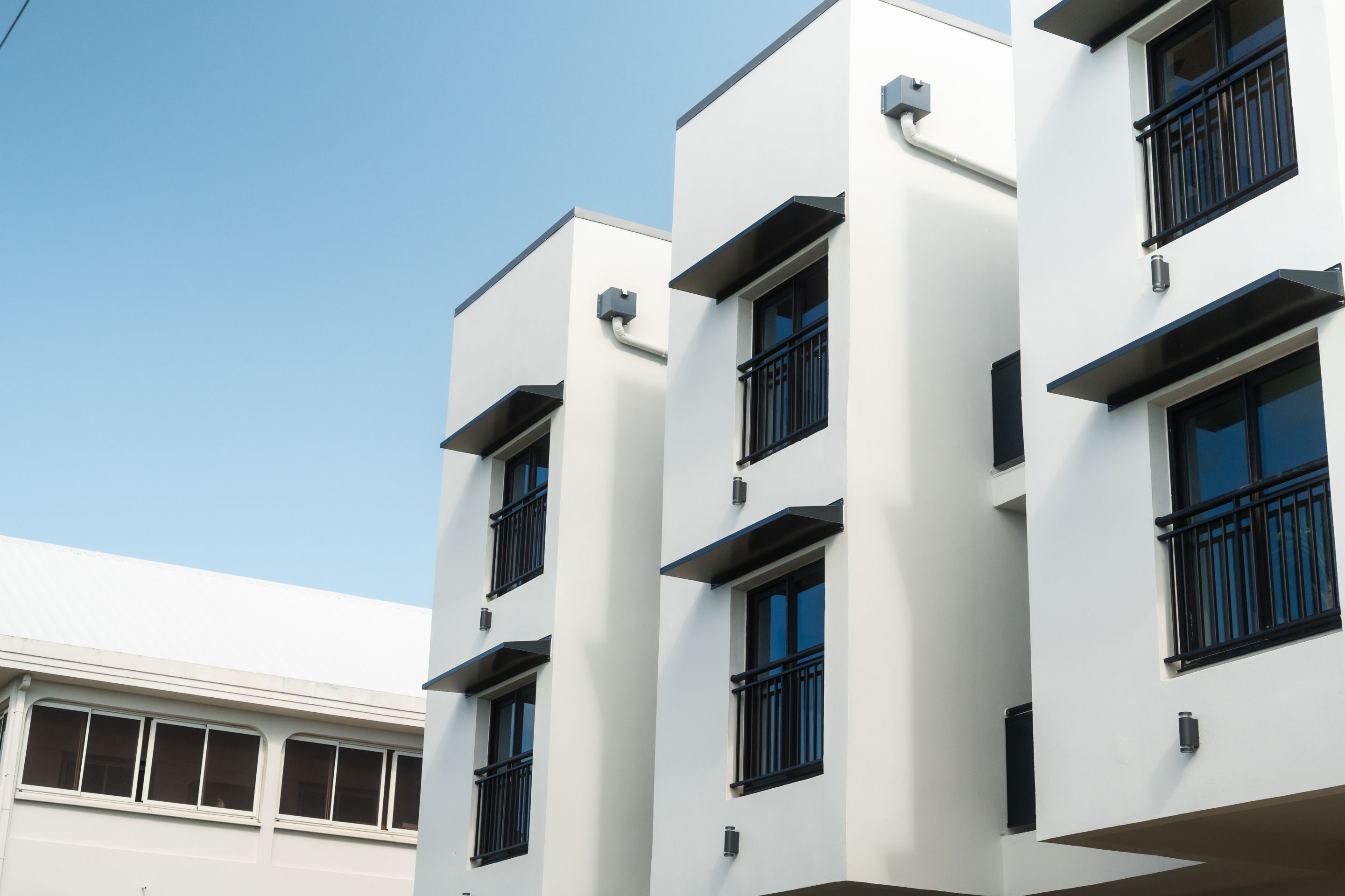 A modern building with multiple floors, large windows, and a flat facade.