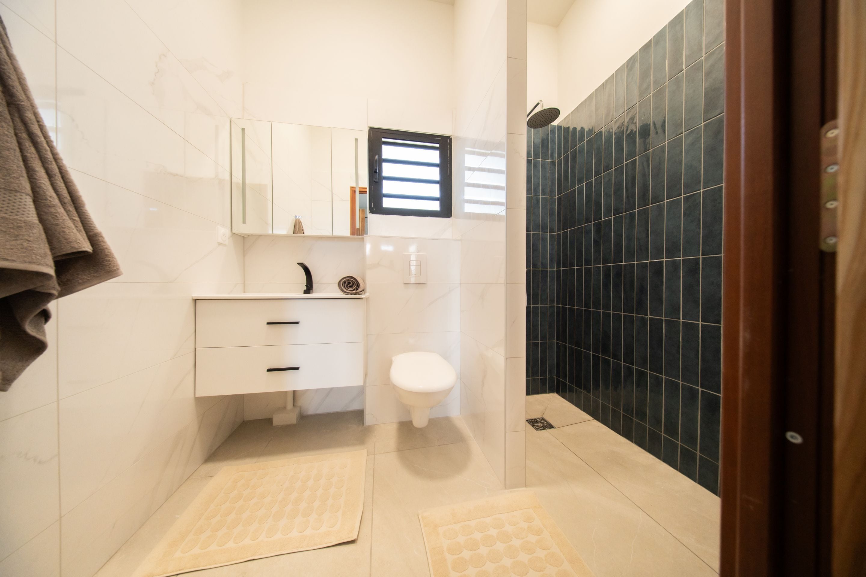 Ein Badezimmer mit Toilette, Waschbecken und Duschbereich.