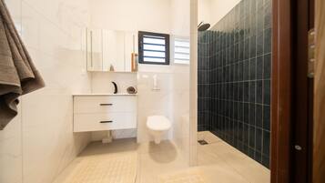 Ein Badezimmer mit Toilette, Waschbecken und Duschbereich.