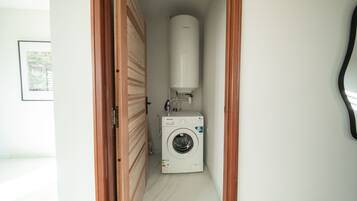 A laundry room with a washing machine and a water heater.