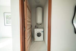 A laundry room with a washing machine and a water heater. - Takeoff (SAINTE-MARIE)