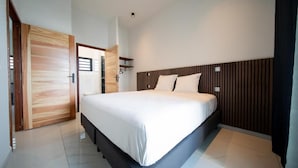 A modern bedroom with a large bed, wooden paneling on the headboard, and a bright, clean design. - Takeoff (SAINTE-MARIE)
