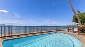 Una piscina con vistas al mar y una valla.