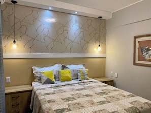 A bedroom with a bed, bedside tables, a wall with a crackled pattern, and pendant lights. - 1303  Nobre e Moderno com Garagem (Belém)