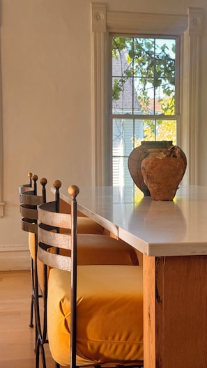 A dining area with a marble table, a vase, and a chair with a unique backrest design. - Mediterranean Retreat. Newly renovate 1,000 sqft. (Chicago)