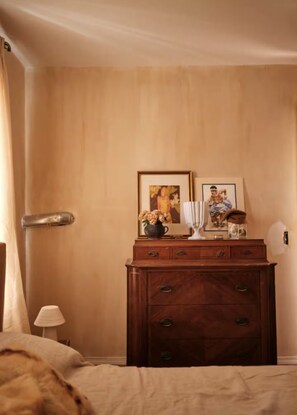 A room with a wooden dresser, a bed, a lamp, and two framed pictures on the wall. - Mediterranean Retreat. Newly renovate 1,000 sqft. (Chicago)