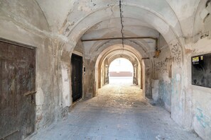 A corridor with arched ceilings, a brick floor, and graffiti on the walls. - Spacious 2-Bedroom Apartment | Air-conditioning | City Centre (Lublin)