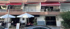 A building with outdoor seating, a sign for 'ALEXIS II', and a car parked in front. - Golden Aventura Salou (Salou)