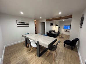 A modern living space with a dining area, a sofa, a TV, and a wooden floor. - The Refuge of the Six Valleys • House for 8 people, 4 bedrooms  • Wi-Fi• Near the Alps (Livet-et-Gavet)
