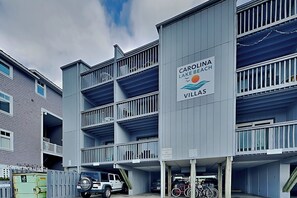 A multi-story building with a sign indicating it is part of the Carolina Lake Beach Villas. - Sandal Suite | Coastal Condo with Private Balcony + Pool Access (Carolina Beach)