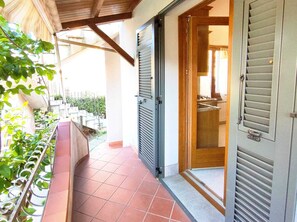 Ein Balkon mit Fliesenboden, Metallgeländer und Blick auf ein Wohngebiet.
