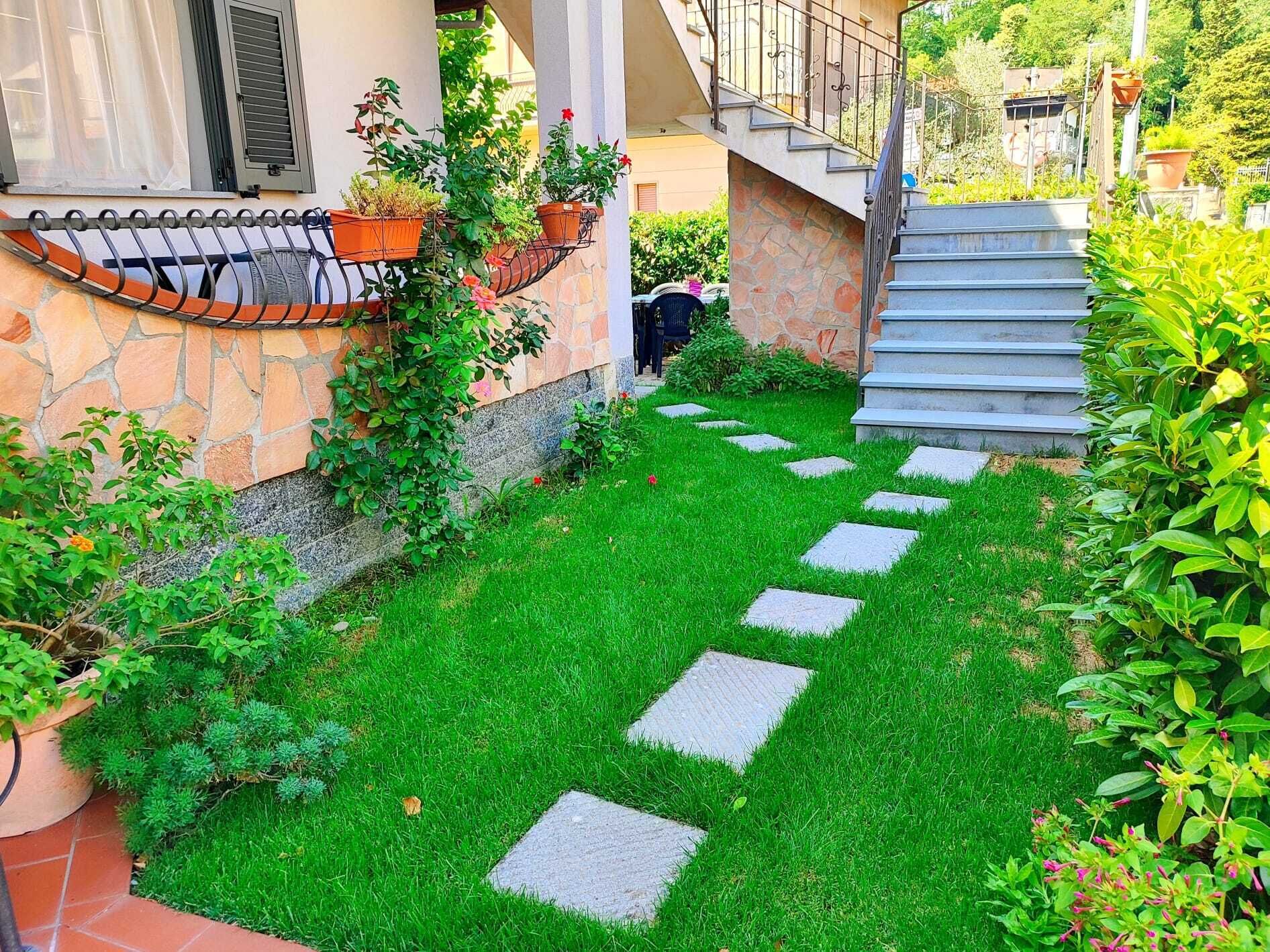Un giardino curato con un vialetto in pietra che conduce a una scala.
