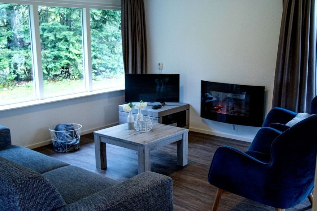 A living room with a sofa, a coffee table, a flat-screen TV, and a fireplace.