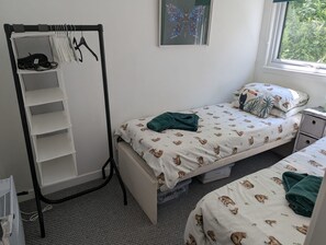 Ein Schlafzimmer mit einem Bett, einem Kleiderschrank, einem Fenster und einem Schmetterlingsbild.