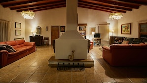A cozy living room with a fireplace, red sofas, and a tiled floor. - w Nature Retreat 4BR w Pool BBQ in Ca ete (Quilmaná)