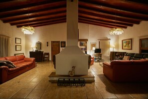 A cozy living room with a fireplace, red sofas, and a tiled floor. - w Nature Retreat 4BR w Pool BBQ in Ca ete (Quilmaná)