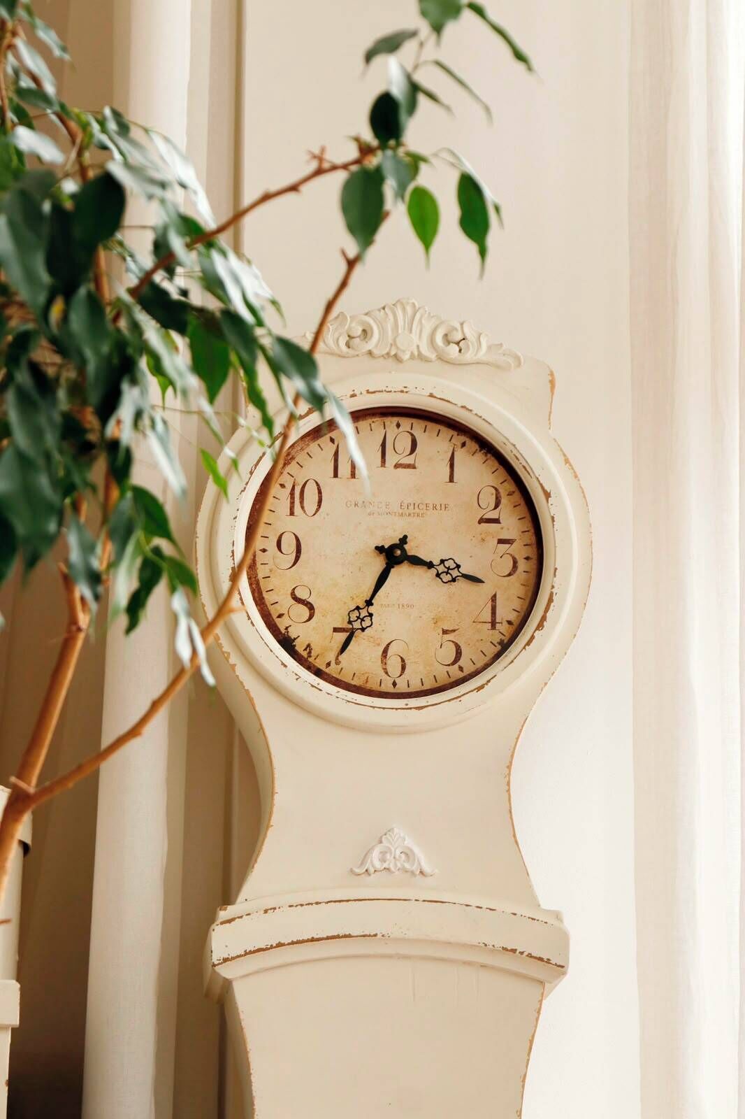 A wall-mounted clock with a vintage design, featuring Roman numerals and a date of 1890.