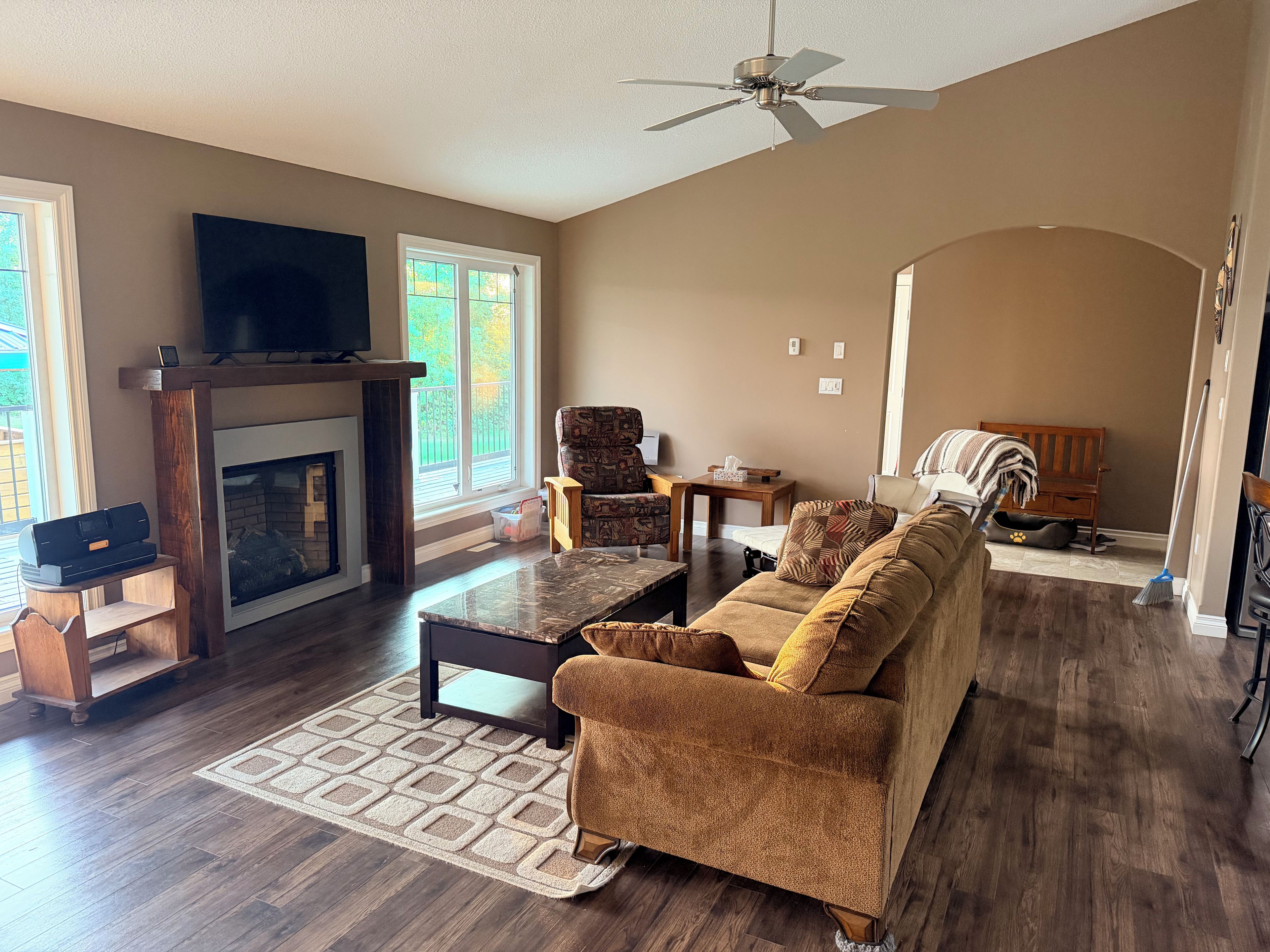 A living room with a fireplace, sofa, coffee table, and a television.
