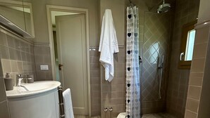 Een moderne badkamer met een gebogen douche, een wastafel en een spiegel.