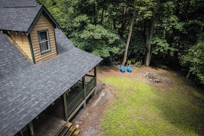 A wooden cabin with a porch, surrounded by a forested area. - Cozy 2-bedroom cabin in tranquil Sylva with AC (Sylva)