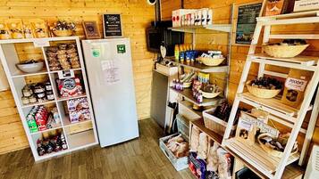 A wooden interior with a refrigerator, shelves stocked with snacks, and a sign indicating a 9.4 rating.