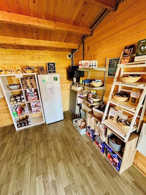 A wooden interior with a refrigerator, shelves stocked with snacks, and a sign indicating a 9.4 rating.