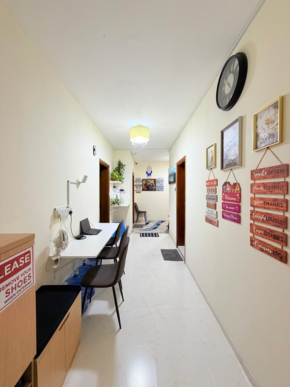 A hallway with a reception desk, a clock, and motivational wall decorations.