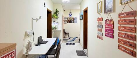 A hallway with a reception desk, a clock, and motivational wall decorations.