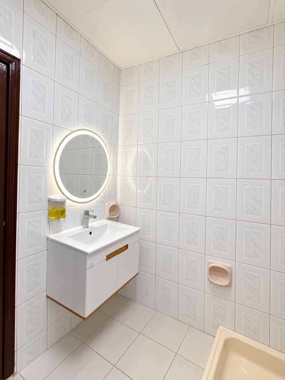 A bathroom with a white sink, mirror, and a toilet.