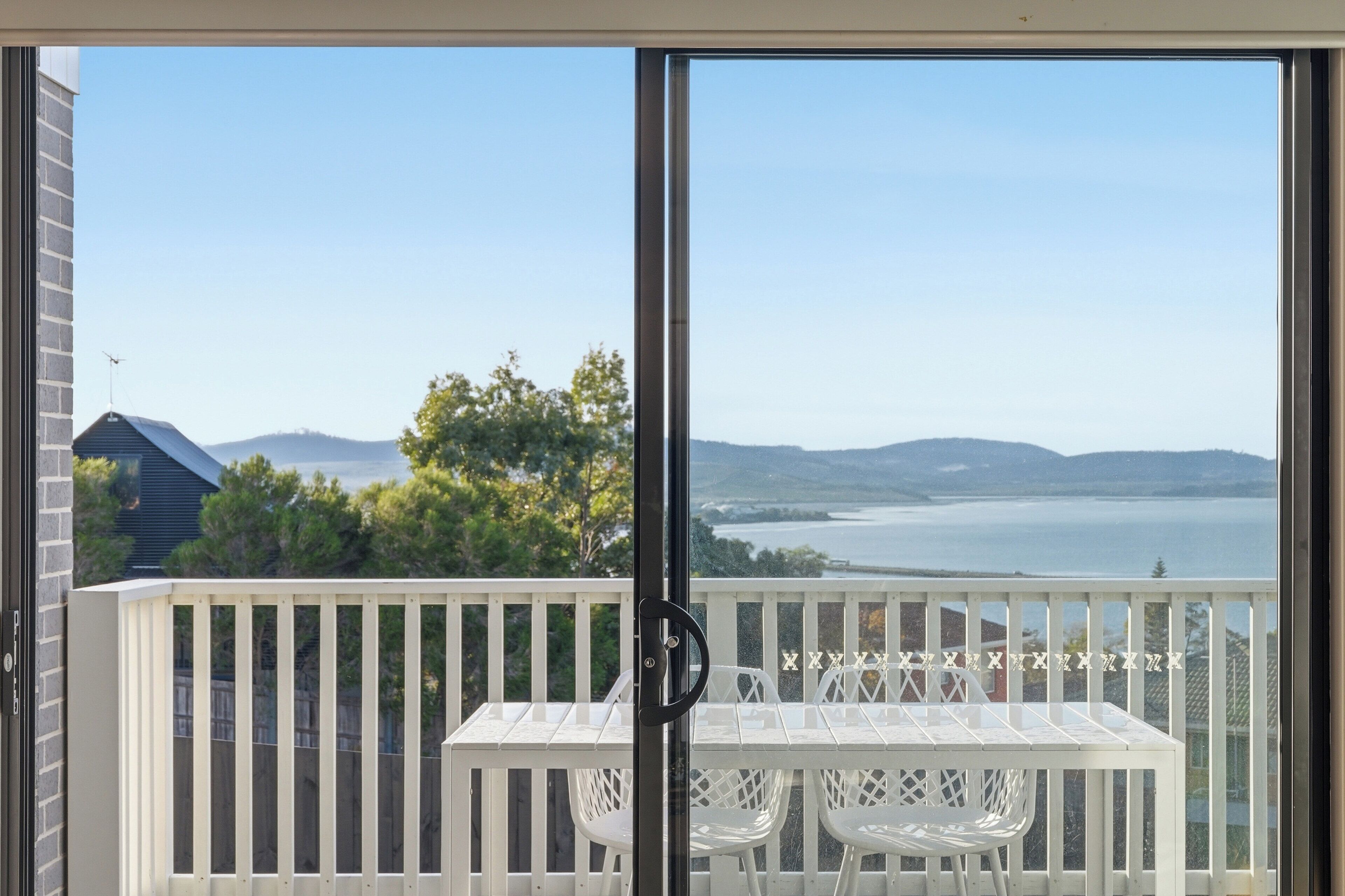 En balkon med gelænder, et bord og to stole.
