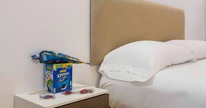 A hotel room with a bed, a nightstand, and a box of mini Oreo cookies.
