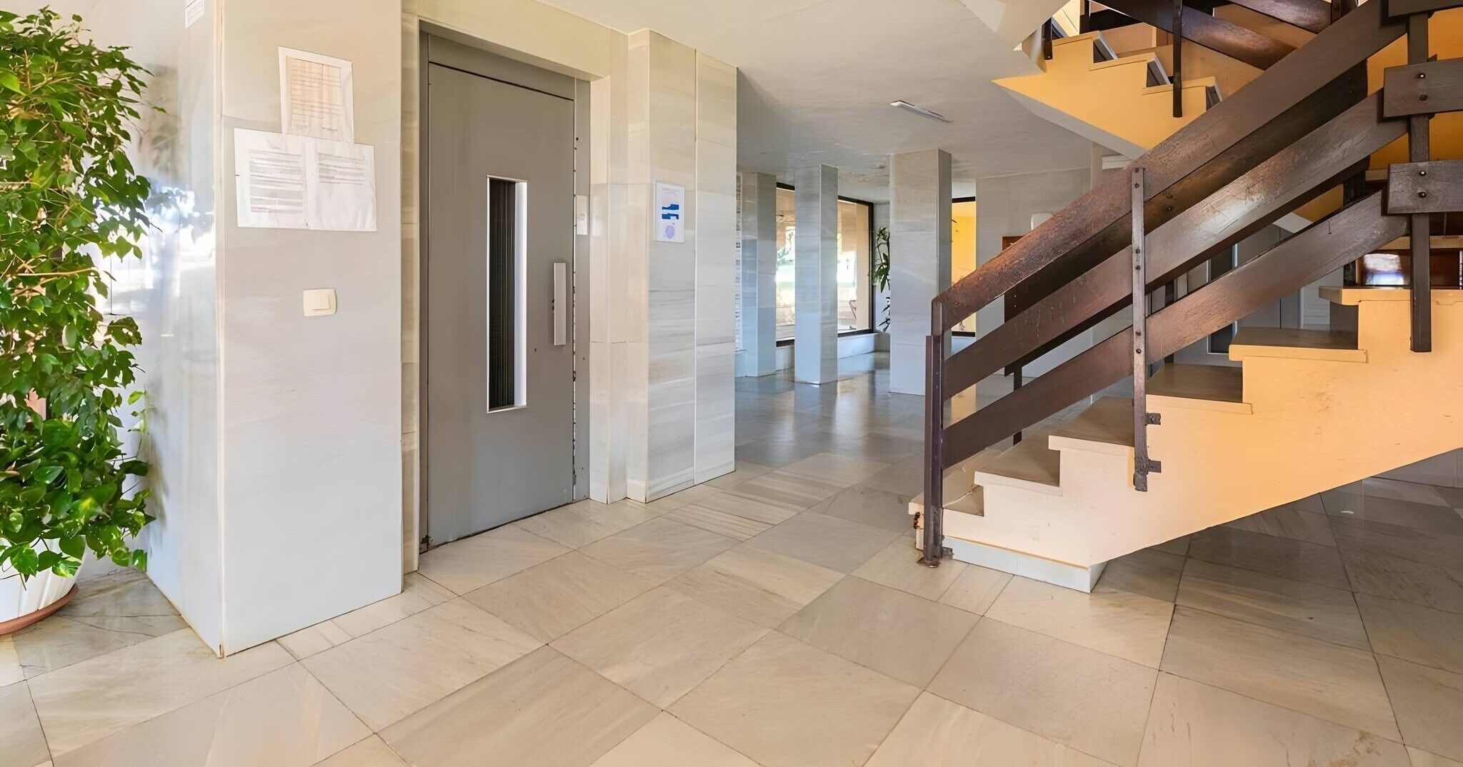 Un intérieur moderne avec un escalier, une porte et une plante en pot.