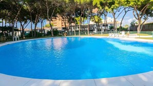 Una piscina azul clara rodeada de árboles y edificios.