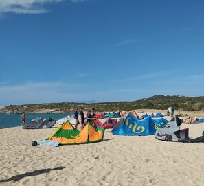 Ein Strand mit mehreren bunten Zelten und Menschen.