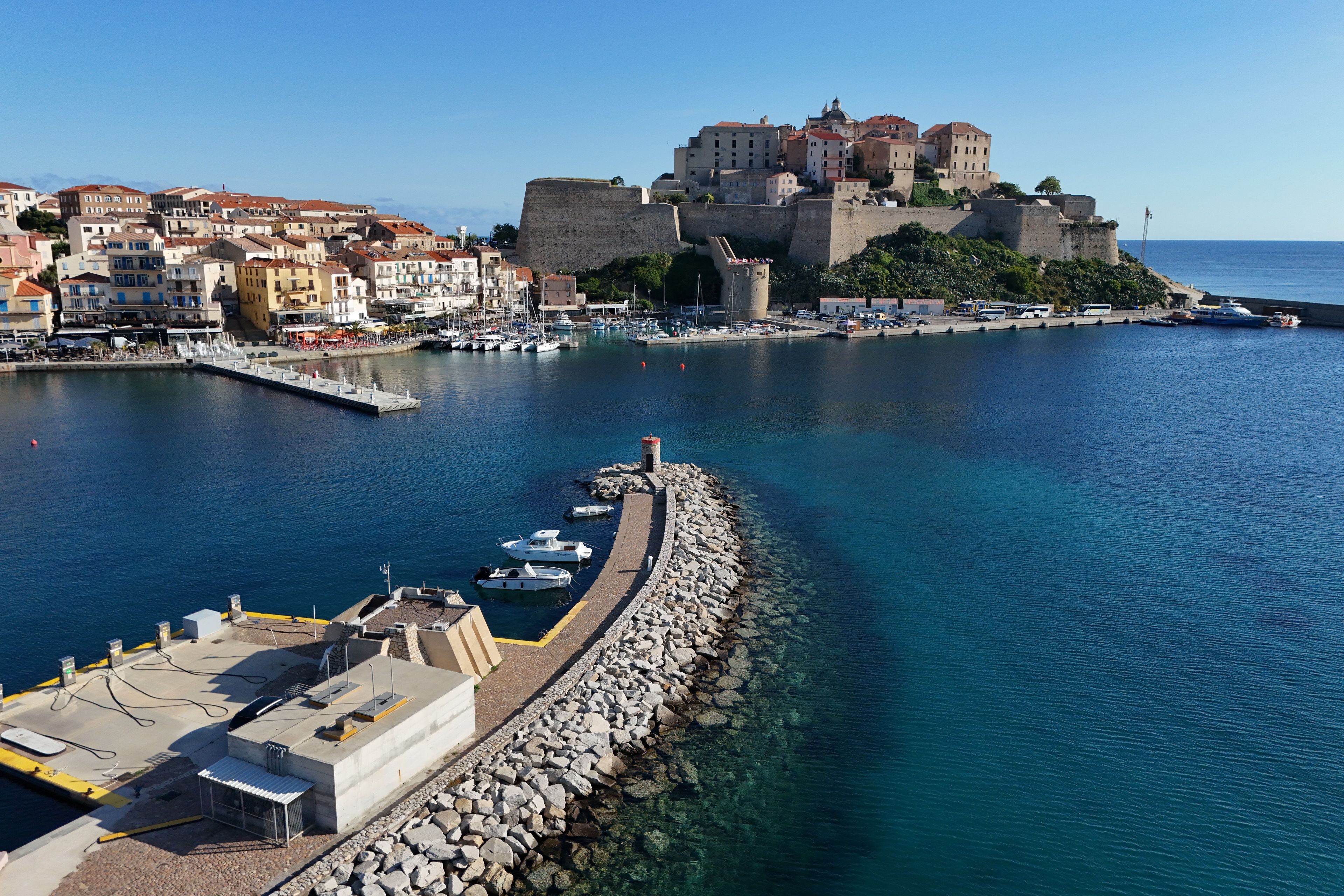 A coastal town with a historic fort and a marina.
