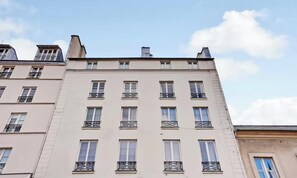 A multi-story building with a uniform facade, multiple balconies, and a clear sky. - AN IDEAL BASE FOR EXPERIENCING THE VERY BEST OF THE FRENCH CAPITAL-SAINT GERMAIN (Paris)