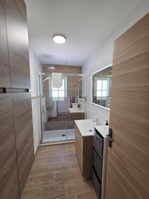 Ein modernes Badezimmer mit Dusche, Toilette und Waschbecken.