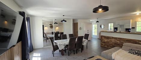 Una sala de estar moderna con un sofá, una mesa de centro y un comedor con sillas y una mesa.