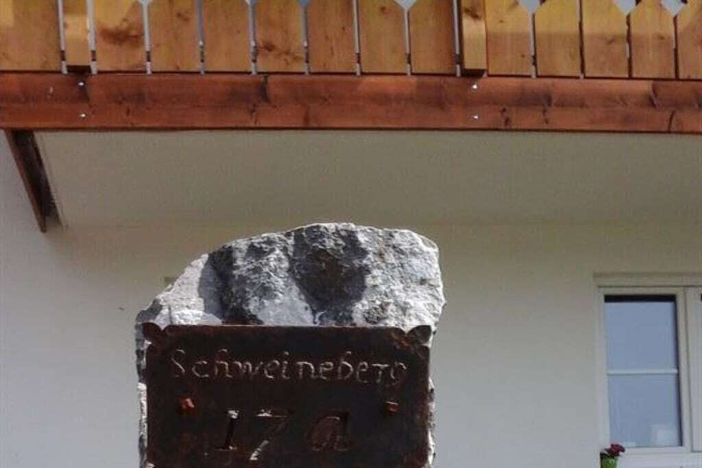 A stone plaque with the inscription 'Schweineberg 47a' mounted on a wooden structure.