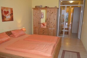 Un dormitorio con una cama, un armario y un espejo.