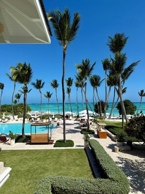 Un resort con piscina, palmeras y vista al océano.