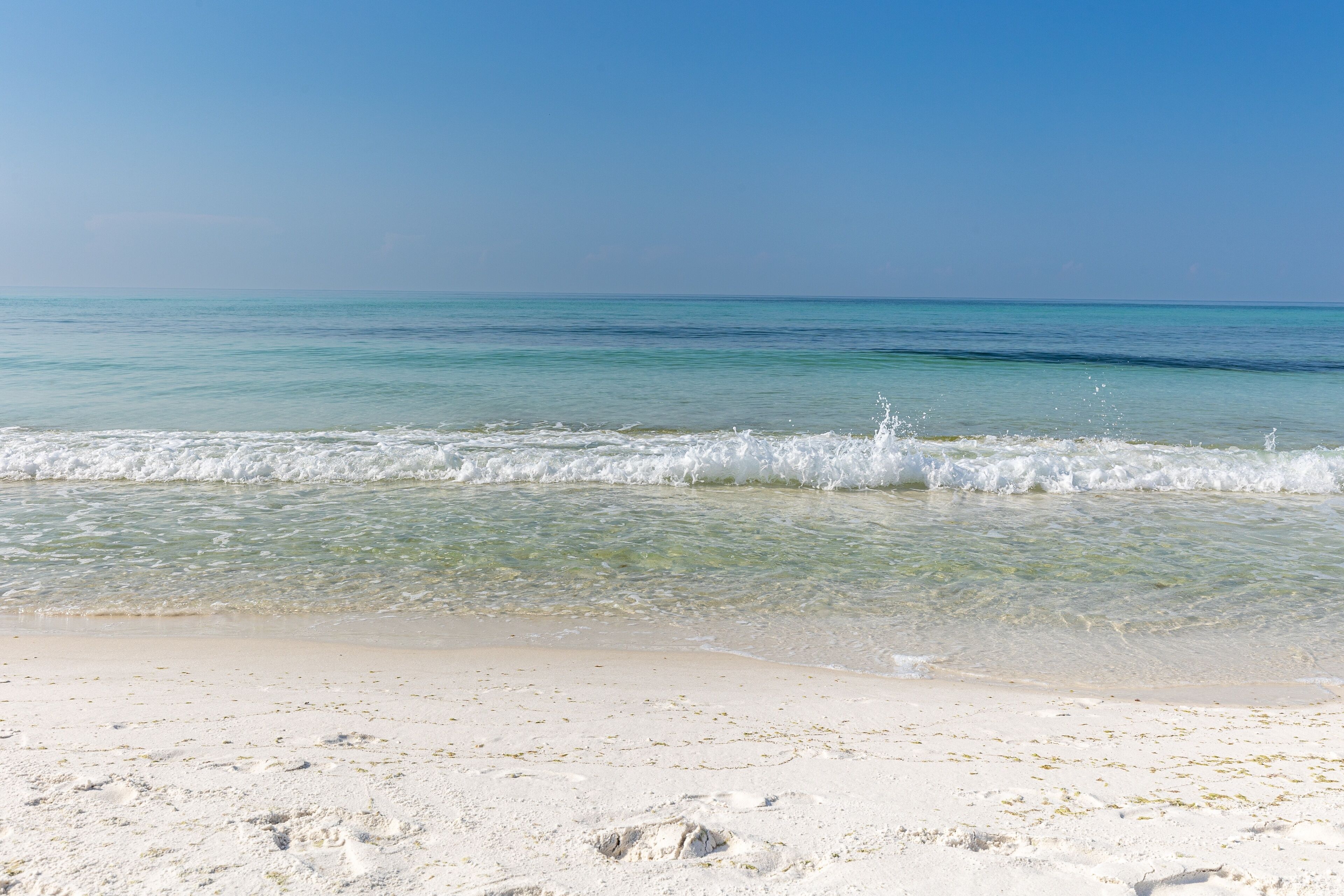 A beach with clear turquoise water and white sand.
