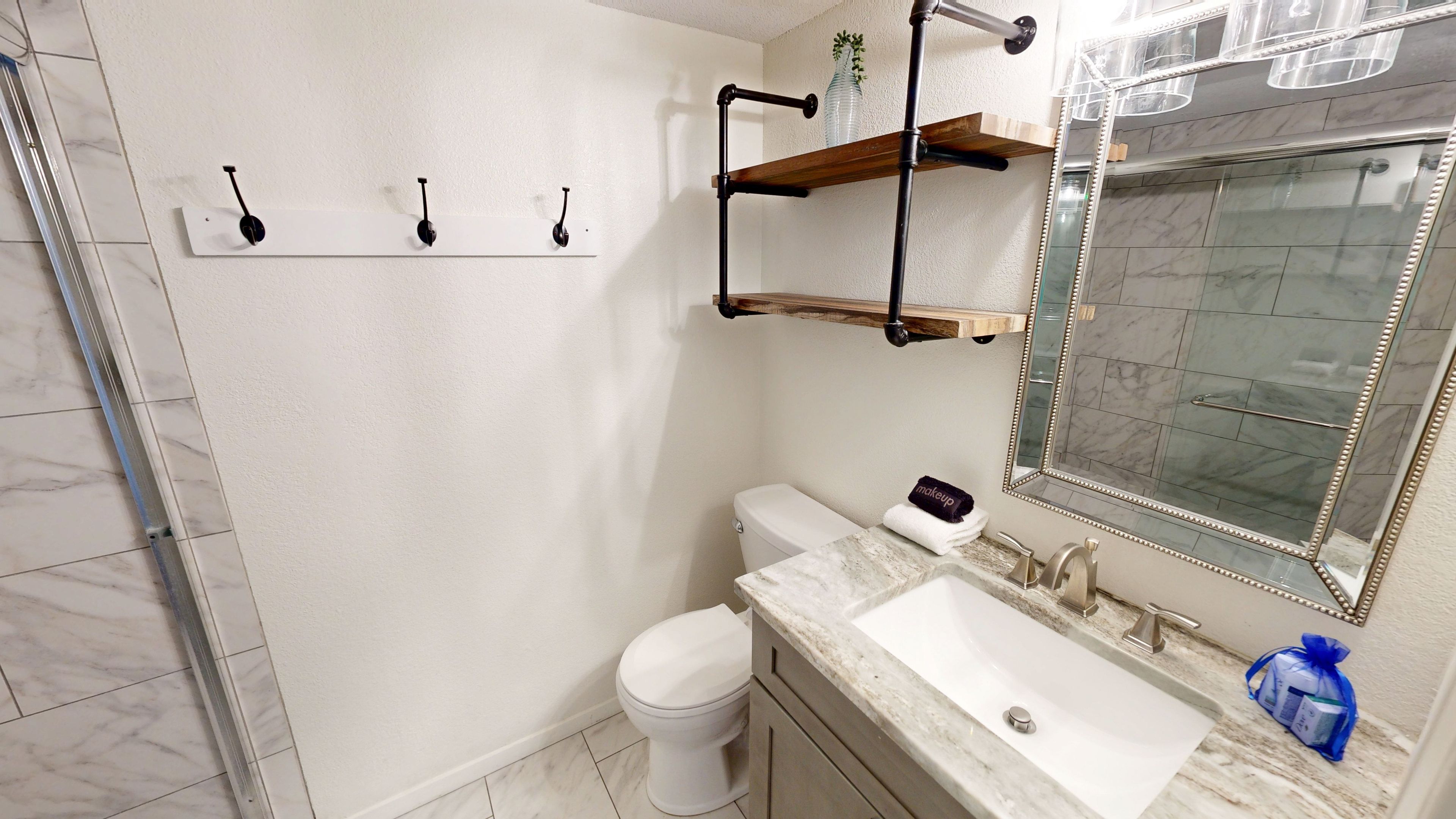 Ein Badezimmer mit Toilette, Waschbecken, Spiegel und Handtuchhalter.