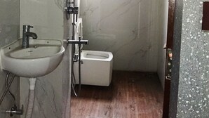 Ein kleines Badezimmer mit Waschbecken, Toilette und Dusche.