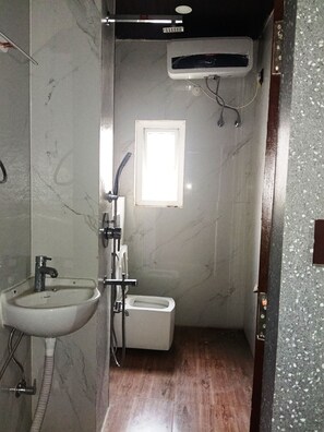 A small bathroom with a sink, toilet, and shower. - Urban Oasis (Guwahati)