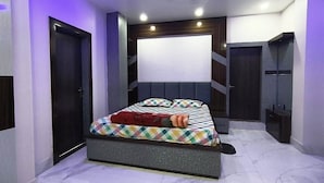 Ein Schlafzimmer mit Bett, Kopfteil, einer Tür und einer Deckenleuchte.