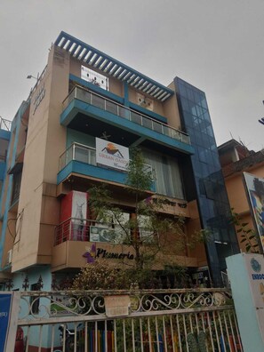 A multi-story building with a sign for 'Urban Oasis' and a pharmacy named 'Pharmacy'.