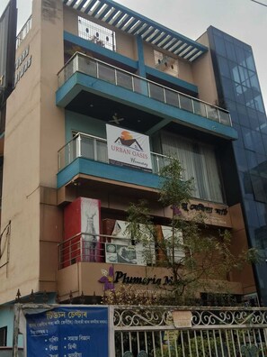 A multi-story building with a sign for 'Urban Oasis Homestay' on the second floor. - Urban Oasis (Guwahati)