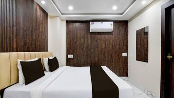 A modern hotel room with a large bed, wooden panel walls, an air conditioning unit, and a marble floor.